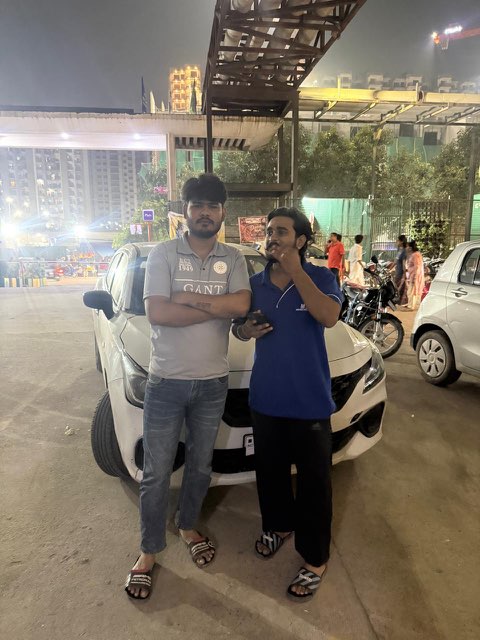 Two WheelKing customers with the white Maruti Suzuki they got through online car booking in Noida