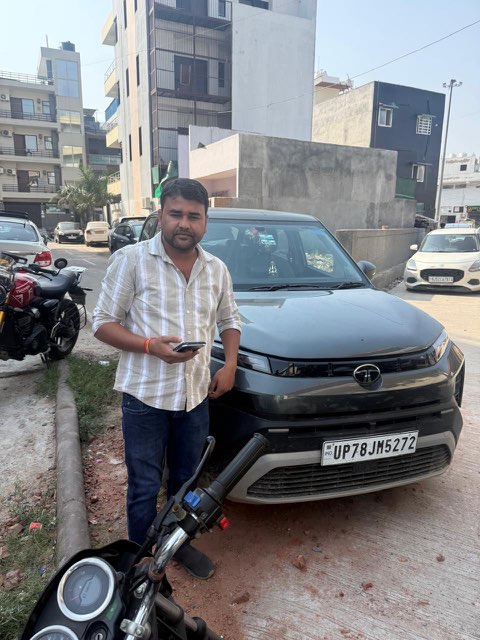 WheelKing customer beside a grey Tata SUV from our self drive car rental in Greater Noida West