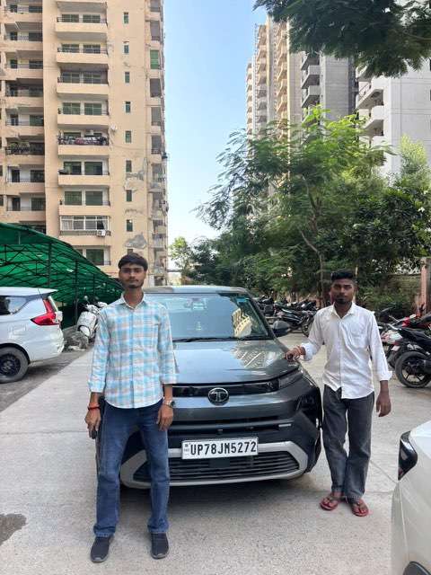 Two customers with their grey Tata SUV from WheelKing, self drive rental cars near Greater Noida West